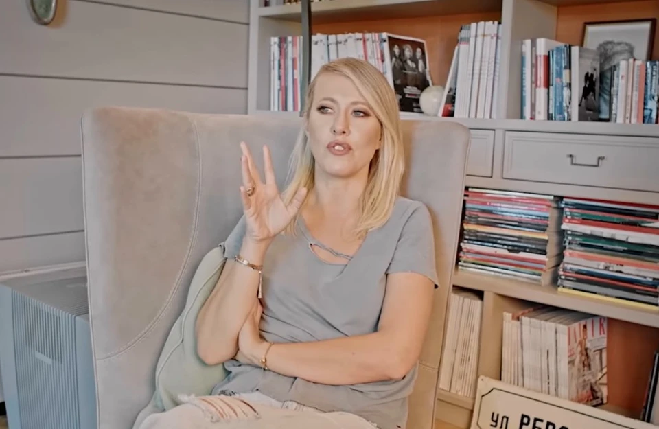 Ксения Собчак в гостиной у полок с книгами. Фото: YouTube-канал «Осторожно, Собчак!»